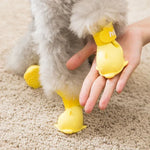 Waterproof cartoon dog shoes on a pet's paws, showcasing silicone yellow boots with a hand for size comparison.
